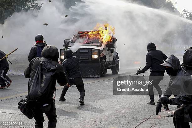 Demonstrators throw stones and molotov cocktail at the police cars as protesters clash with police during a demonstration commemorating International...