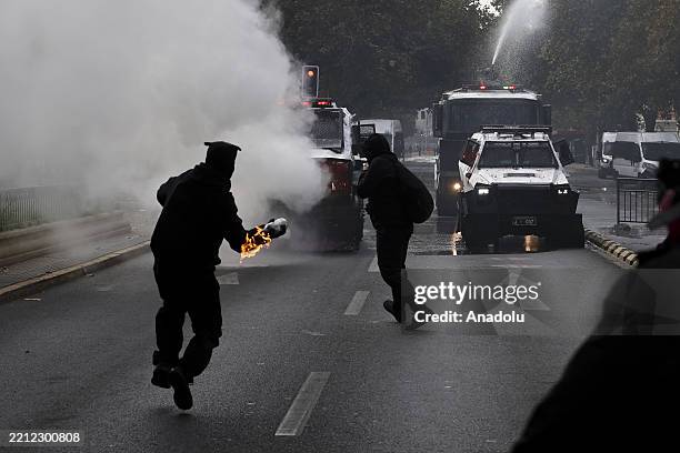 Demonstrator throws molotov cocktail at police cars as protesters clash with police during a demonstration commemorating International Workers' Day...