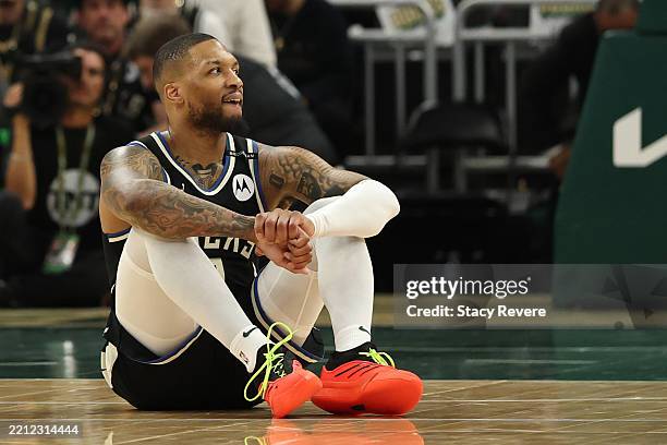 Damian Lillard of the Milwaukee Bucks reacts from the court after an apparent injury during the first quarter in Game Four of the Eastern Conference...