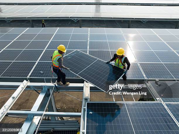 workers are installing awning solar panels - zonne energie stockfoto's en -beelden