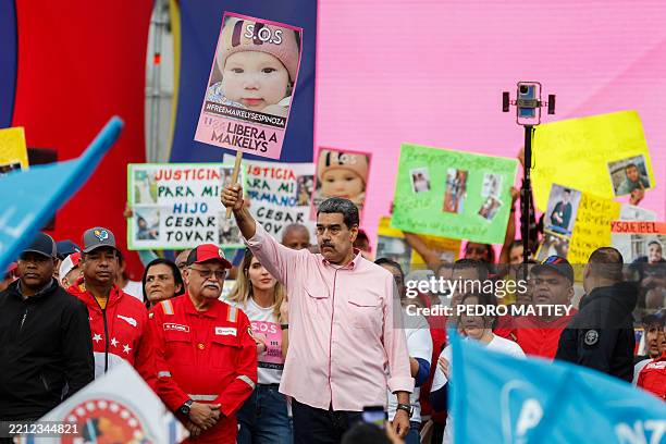Venezuela's President Nicolas Maduro holds a sign with the portrait of Maikelys Espinoza, 2 years old, a child held in the United States, during a...