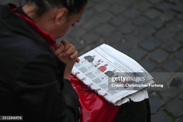 Woman reads a newspaper listing the cardinals who could possibly become the new Pope on April 28, 2025 in Rome, Italy. Funeral rites for the late...