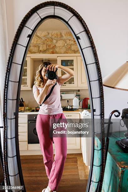 giovane donna che scatta una fotografia di se stessa in uno specchio con una fotocamera digitale - selfie-in-mirror foto e immagini stock