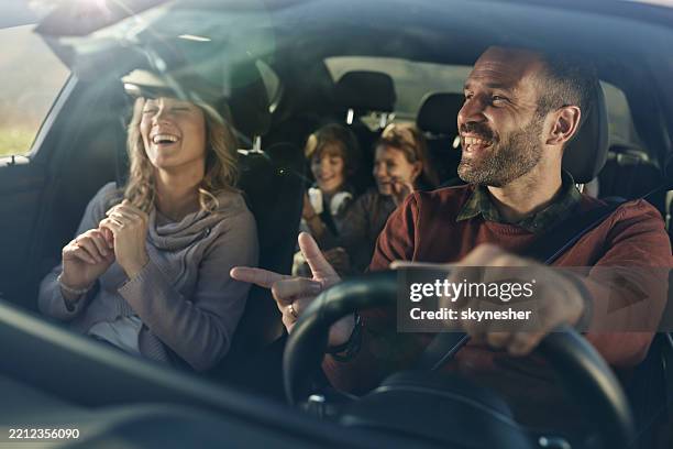 familia feliz escuchando música mientras se va de viaje por carretera en coche. - interior coche fotografías e imágenes de stock