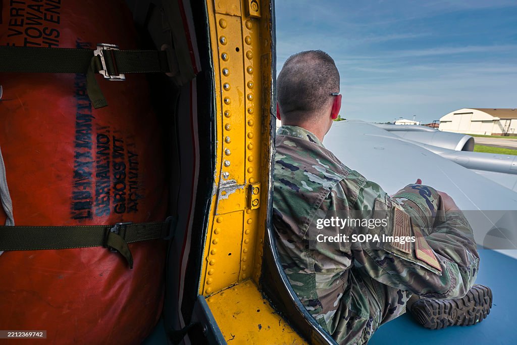 A crew member sits outside on the wing to escape the heat...