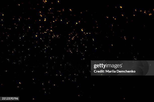 gold bokeh lights on black background. glitter sparkle stars overlay - scattered stock pictures, royalty-free photos & images