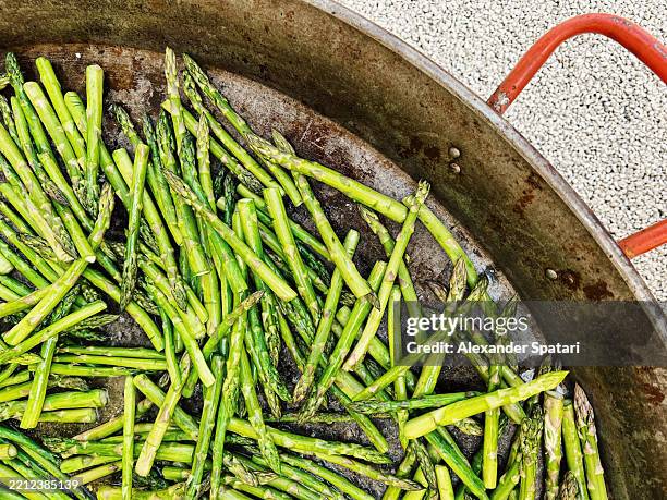 asparagus on a large frying pan at a summer festival - large frying pan stock pictures, royalty-free photos & images