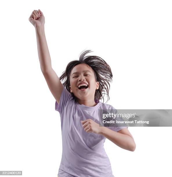 a young girl is jumping up and down with her arms raised in the air - little asian girl jumping stock pictures, royalty-free photos & images
