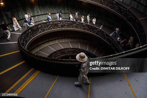 Visitors walk down the Bramante Staircase at The Vatican Museums, during a press tour at the Vatican on May 2, 2025.