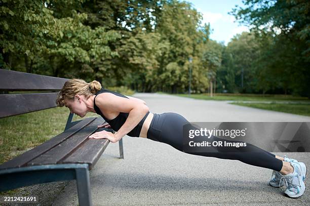 active woman exercising in public park on a park bench - bodyweight training stock pictures, royalty-free photos & images