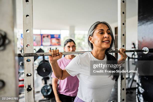 mature woman doing exercises at gym - tyngdlyftning bildbanksfoton och bilder
