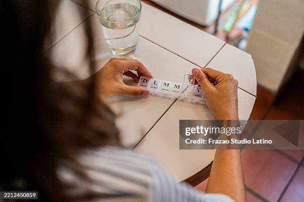 close-up of a woman's hands opening pill organizer at home - pill organizer stock pictures, royalty-free photos & images