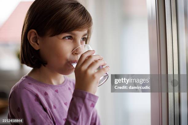 retrato de una linda niña bebiendo un vaso de agua - niño-tomando-agua fotografías e imágenes de stock