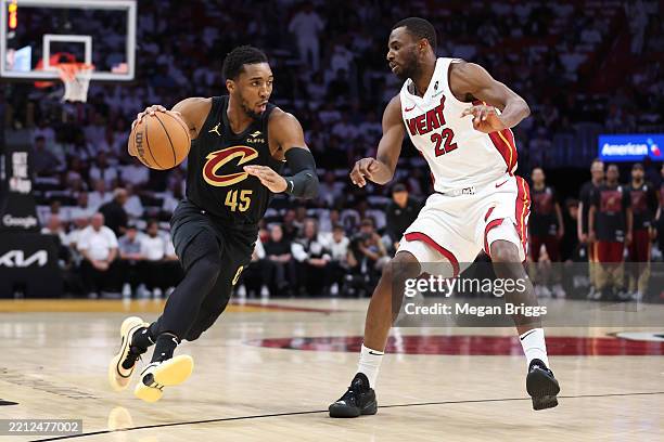 Donovan Mitchell of the Cleveland Cavaliers dribbles the ball against Andrew Wiggins of the Miami Heat during the first quarter in Game Four of the...