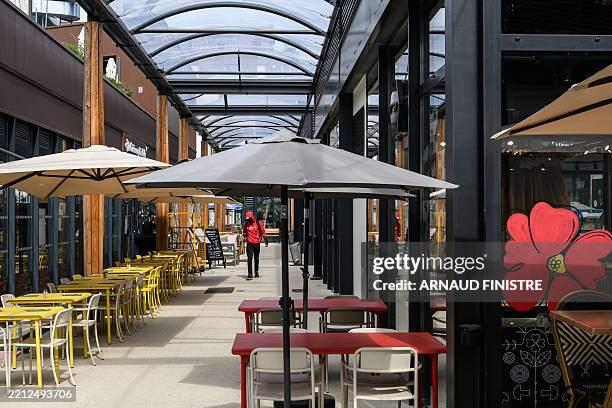 This photo taken on May 2, 2025 shows a visitor walking through the village of the Cité Internationale de la Gastronomie et du Vin in Dijon, central...