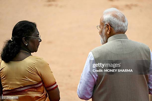 India's President Droupadi Murmu speaks to Prime Minister Narendra Modi during the ceremonial reception of her Angolan counterpart Joao Lourenco at...