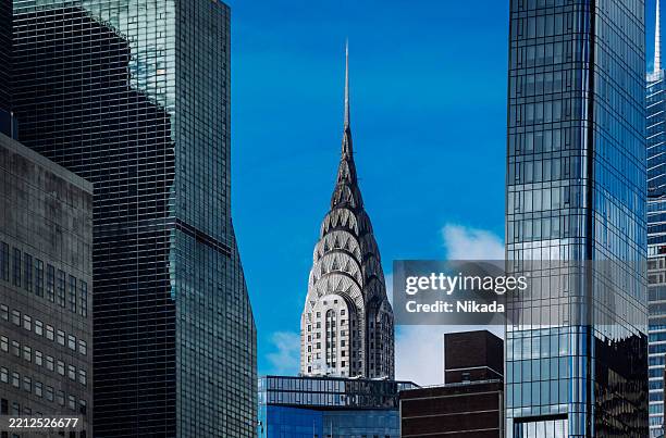 el edificio chrysler en medio del paisaje urbano - edificio chrysler fotografías e imágenes de stock