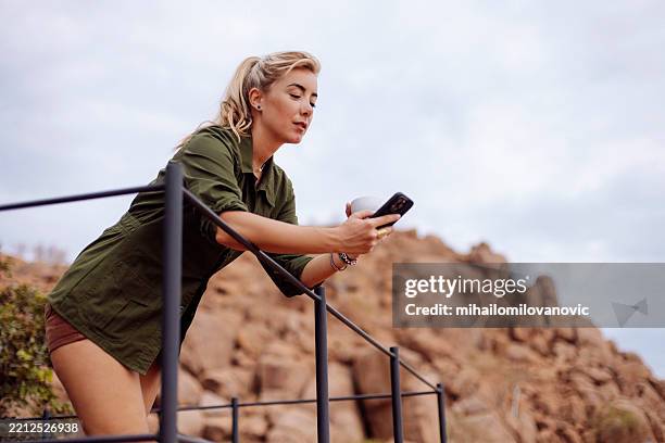 safari woman using cellphone on balcony - safari lodge stock pictures, royalty-free photos & images