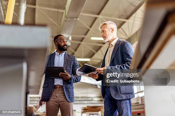 business colleagues discussing work in a modern industrial facility - industrial style stock pictures, royalty-free photos & images