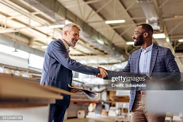 professional businessmen shaking hands during commercial agreement in a modern factory - reliable bildbanksfoton och bilder