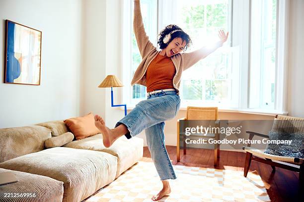 joven extática con auriculares, escuchando música y bailando descalza - independencia fotografías e imágenes de stock