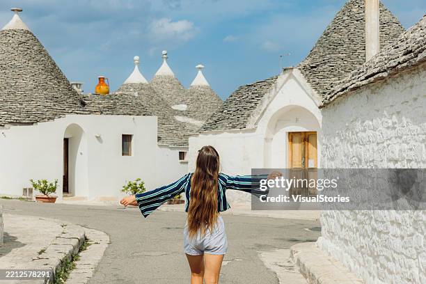 cheerful traveller exploring alberobello city in italy during summer vacation - stone house stock pictures, royalty-free photos & images