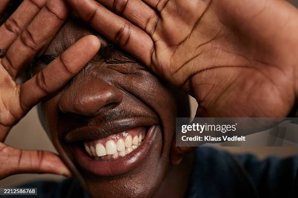 happy young man covering face with hands - man with one tooth stock pictures, royalty-free photos & images