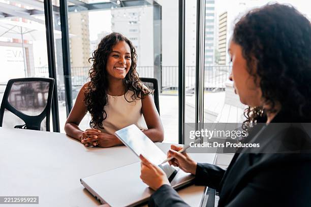 mujer entrevistando a un adolescente para una vacante de trabajo. - entrevista de trabajo fotografías e imágenes de stock