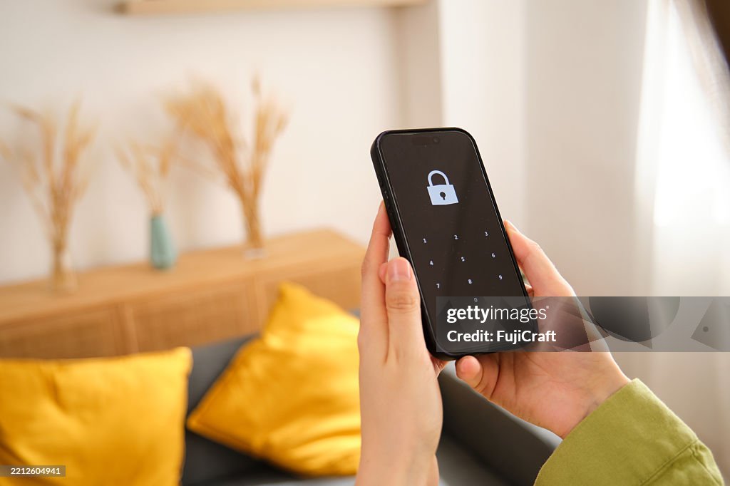 Donna che sblocca lo smartphone con password a casa