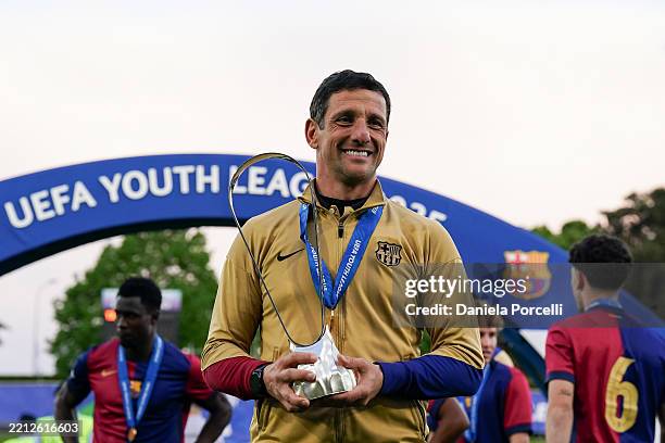 Coach of Barcelona Juliano Belletti poses for a photo with the trophy after winning during the UEFA Youth League 2024/25 Final match between FC...