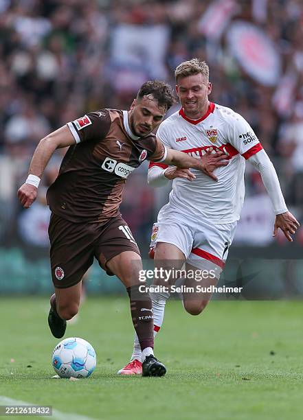 Danel Sinani of St. Pauli fights for the ball with Maximilian Mittelstädt of Stuttgart during the Bundesliga match between FC St. Pauli 1910 and VfB...