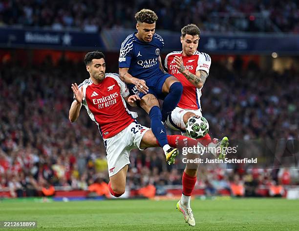Desire Doue of Paris Saint-Germain is challenged by Mikel Merino and Jakub Kiwior of Arsenal during the UEFA Champions League 2024/25 Semi Final...