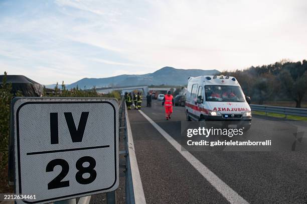 firefighters and italian red cross ambulance at highway accident scene - veículo de serviço de emergência imagens e fotografias de stock