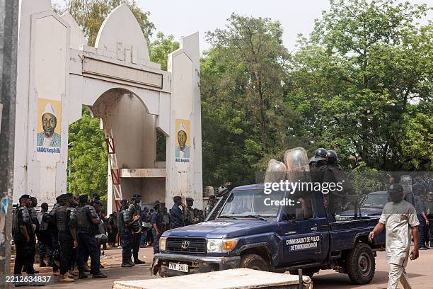 Malian Police officers form a cordon as pro-junta demonstrators hold banners and chant slogans while opposing political parties protest against the...