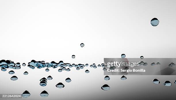 floating water droplets on a reflective surface against a gray background. blender 3d illustration - screen saver stock illustrations