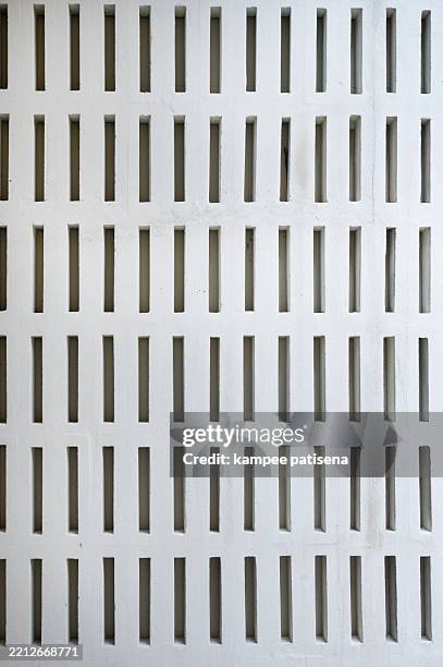 a wall with a pattern of holes - perforated metal stock pictures, royalty-free photos & images
