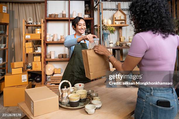 enjoy a shopping experience in a ceramics shop, and experience the magic of handicrafts at the checkout with a cloth bag. - duurzaam consumeren stockfoto's en -beelden