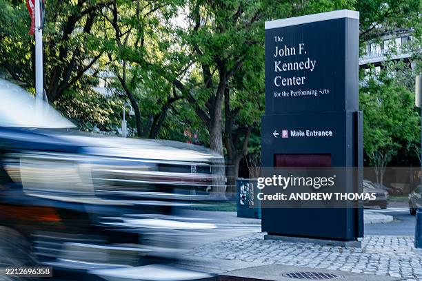 Car speeds past the sign for the John F. Kennedy Center for the Performing Arts in Washington, D.C., on May 2, 2025. People gathered outside of the...