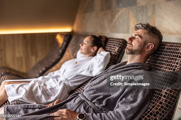 young couple lying on the tepidarium beds in the spa - kuuroord stockfoto's en -beelden