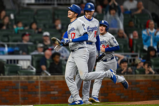 Los Angeles designated hitter Shohei Ohtani scores a run and gets a high-five from teammate Freddie Freeman during the MLB game between the Los...