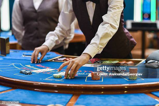 casino blackjack dealer setting chips and cards in place - casino table games stockfoto's en -beelden