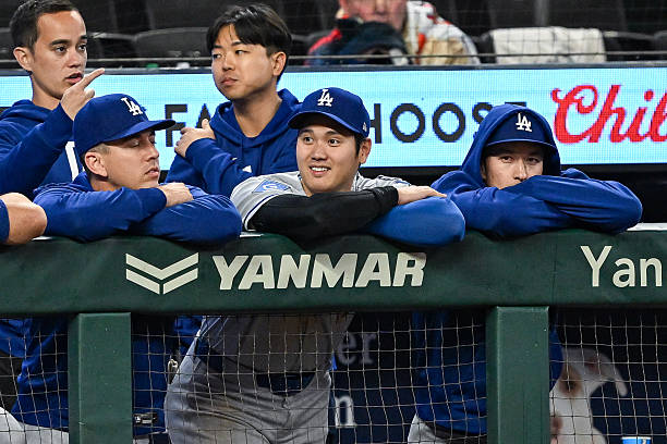 Los Angeles designated hitter Shohei Ohtani hangs out on the dugout rail during the MLB game between the Los Angeles Dodgers and the Atlanta Braves...