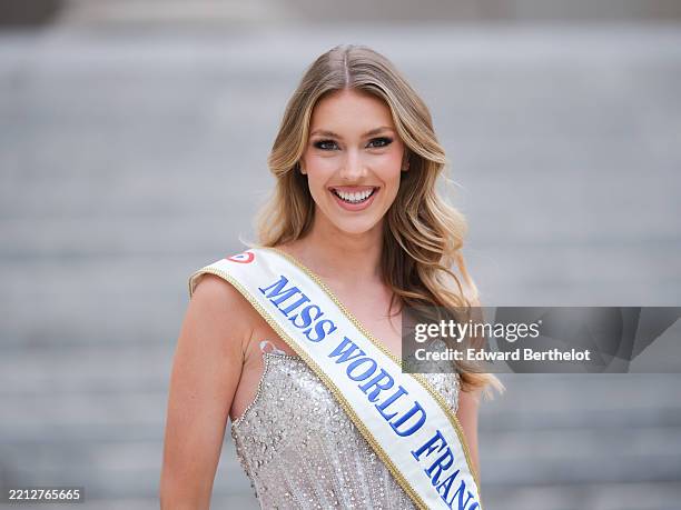 Agathe Cauet, French model and Miss World France 2025 delegate, wears long wavy blonde hair with a side part, natural glowy skin, soft pink lipstick,...