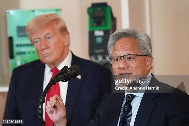 President Donald Trump listens as Nvidia CEO Jensen Huang speaks in the Cross Hall of the White House during an event on "Investing in America" on...