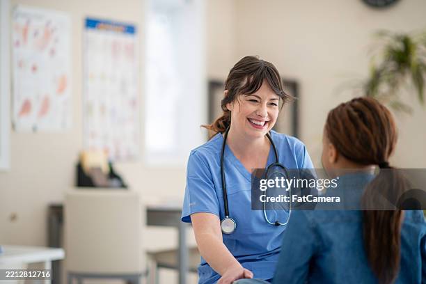 friendly healthcare professional interacting with a patient in a bright clinic - enfermagem imagens e fotografias de stock