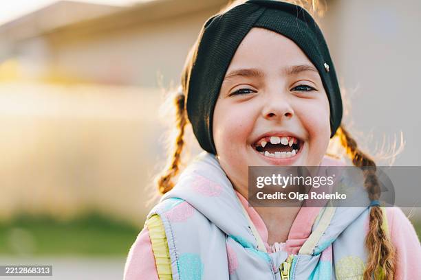 portrait of a cheerful young girl showing her missing teeth and smiling - innocence stock pictures, royalty-free photos & images