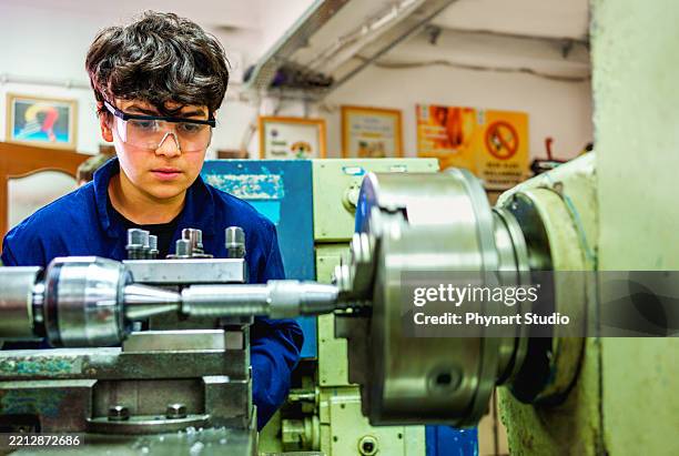 young technician operating lathe machine in workshop - vocational education stock pictures, royalty-free photos & images