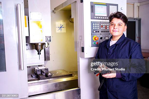teenage student standing next to cnc machine in workshop - cnc operator stock pictures, royalty-free photos & images
