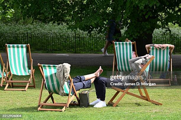 Couple sit in deck chairs enjoying the afternoon sunshine in St James's Park on May 01, 2025 in London, England. The Met Office has confirmed the...