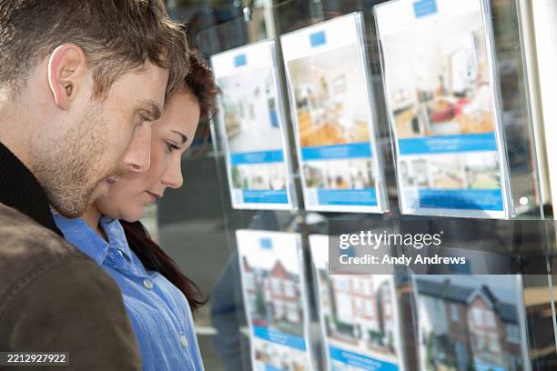 couple looking at houses for sale - huis kopen stockfoto's en -beelden